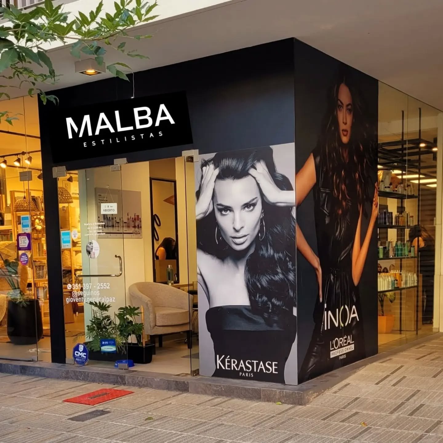 Exterior del salón "Malba Estilistas" con posters de modelos, destacando la estética y profesionalismo del lugar.