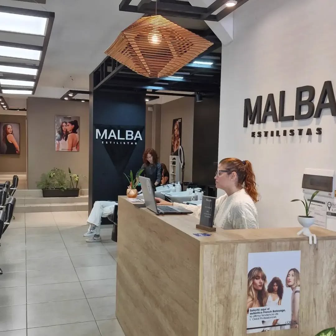 Interior del salón "Malba Estilistas" con posters de modelos, destacando la estética y profesionalismo del lugar.