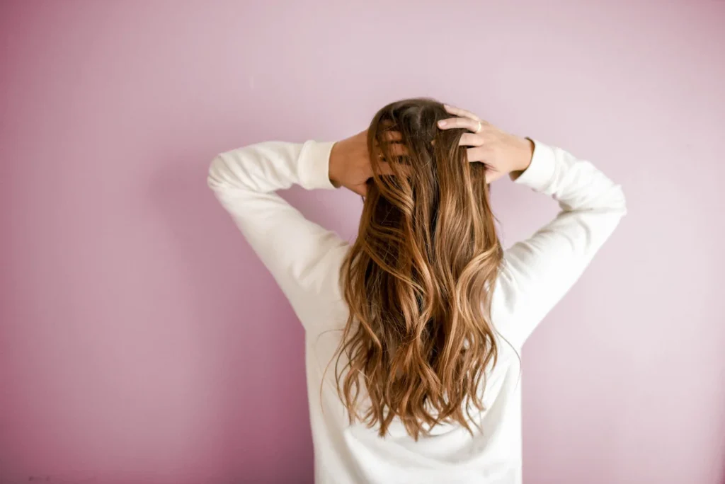 Persona con cabello castaño largo, mostrando un estilo impecable.