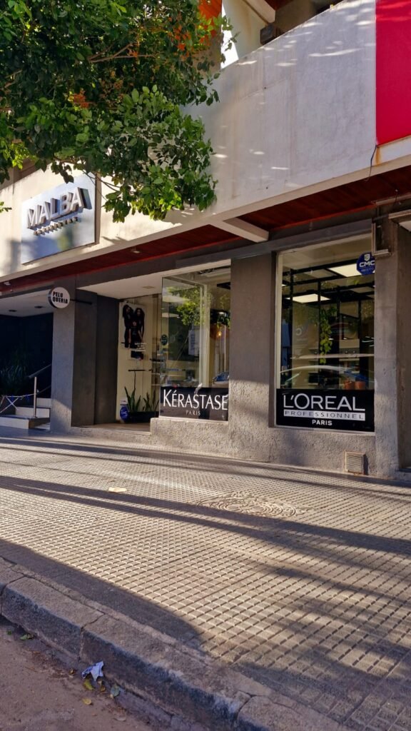 Exterior del salón "Malba Estilistas" con posters de modelos, destacando la estética y profesionalismo del lugar.