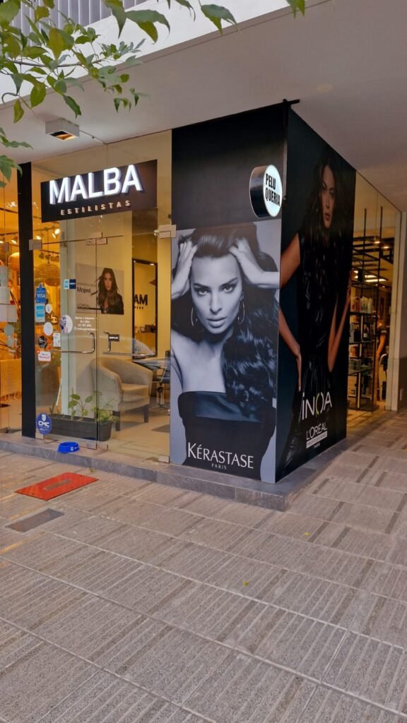 Exterior del salón "Malba Estilistas" con posters de modelos, destacando la estética y profesionalismo del lugar.